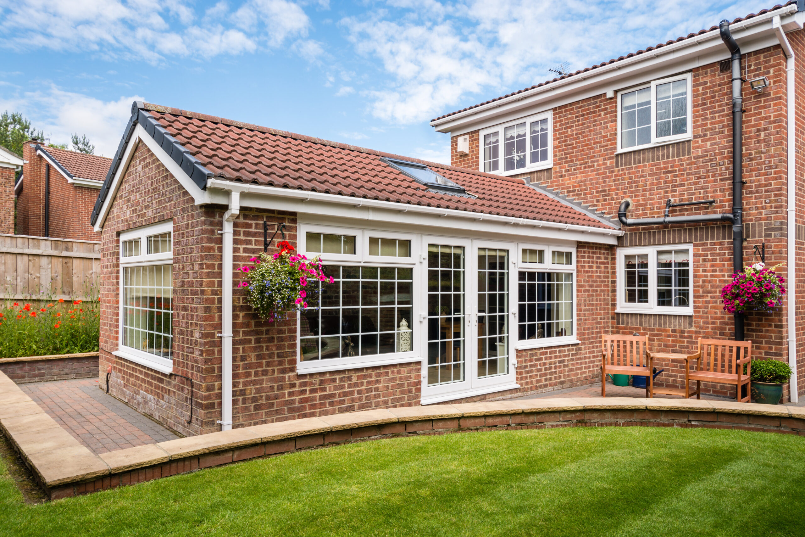 Single-storey brick rear extension with pitched tiled roof and French doors.